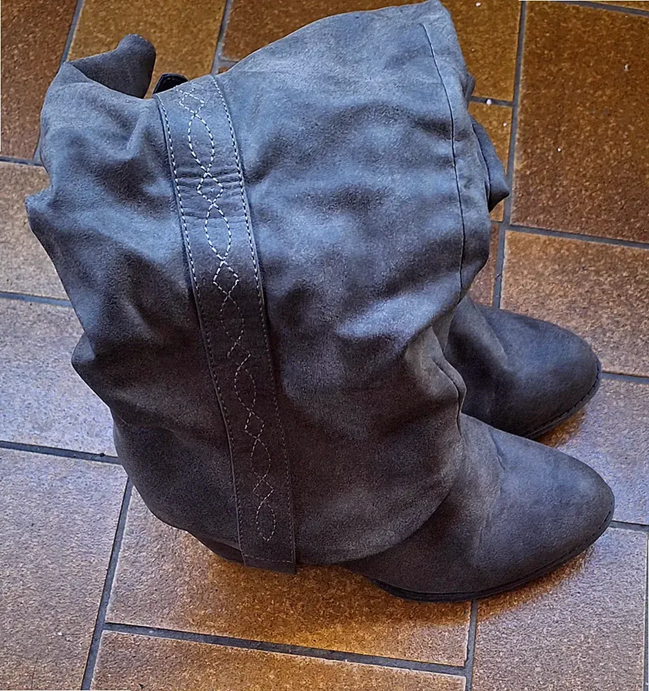 Das sind graue Cowboy- oder Bikerstiefel mit lässigem Schnitt und dickem Absatz.